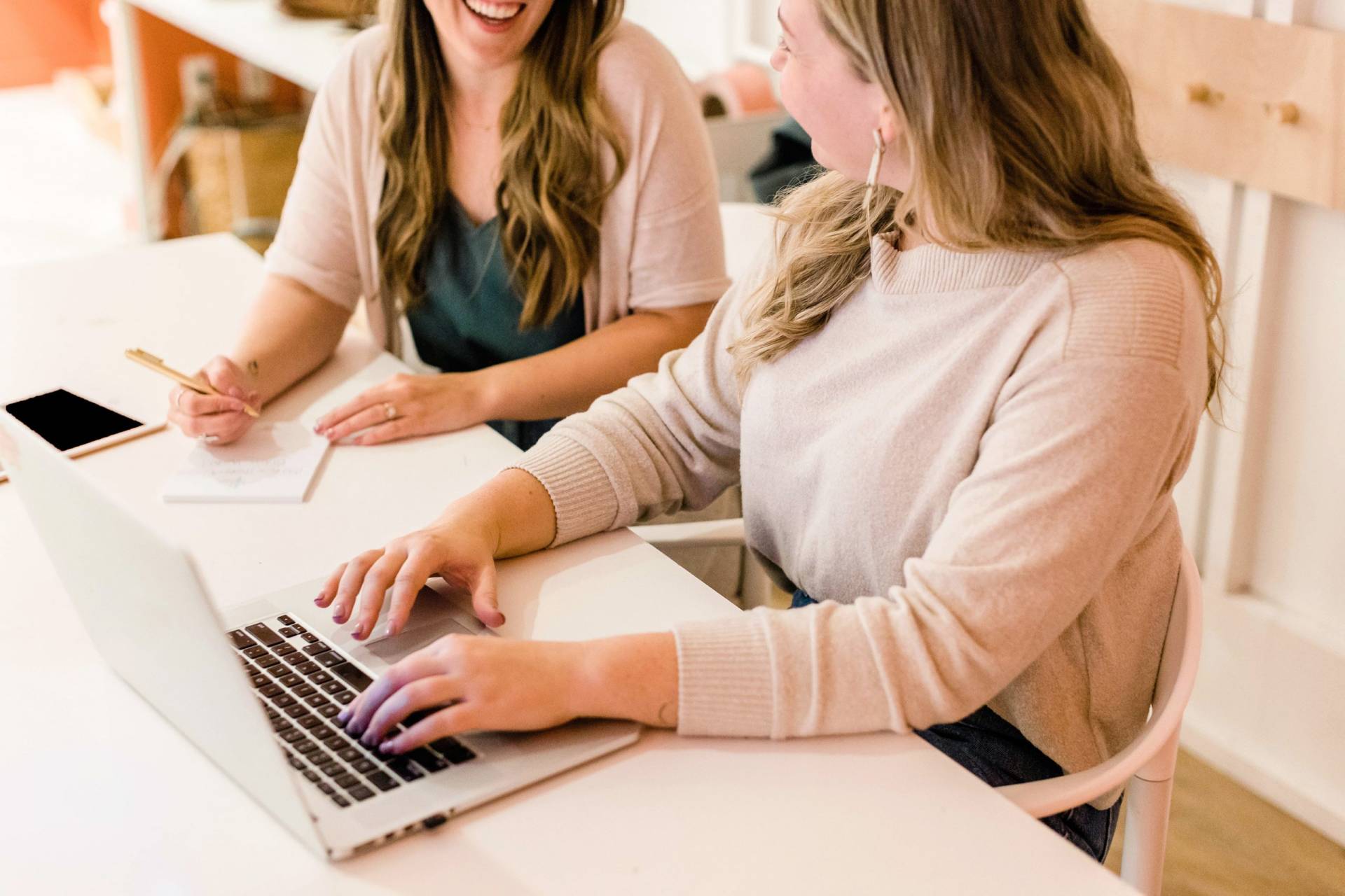 two remote workers working with a laptop on a table